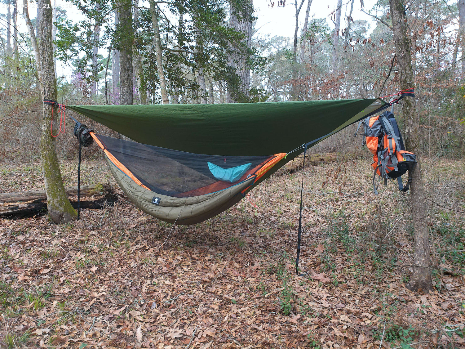 orange ultralight camping hammock with underquilt and tarp and hammock accessories