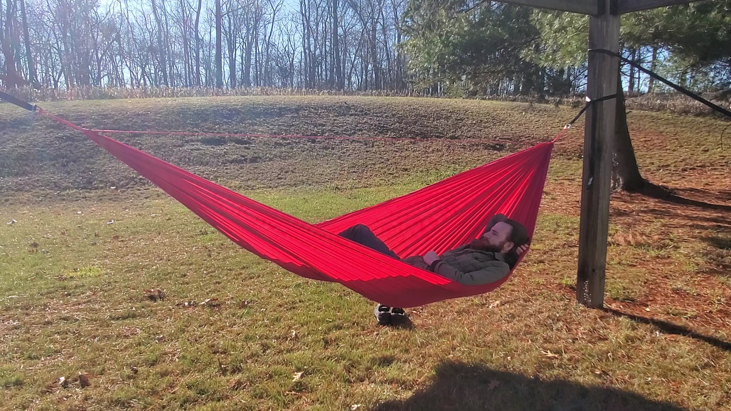 a cool guy named matt smith laying in a red netless camping hammock made from red ripstop nylon fabric from ripstop by the roll rbtr